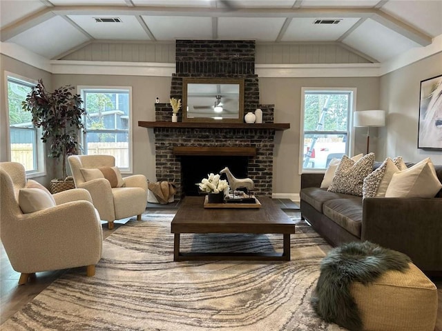 living room featuring visible vents, a brick fireplace, wood finished floors, and vaulted ceiling