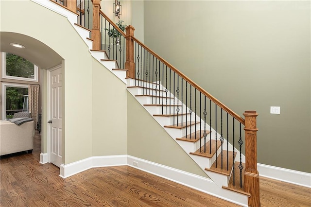 176 Nightwind Trce, Acworth, GA 30101 - staircase featuring wood finished floors, baseboards, and arched walkways