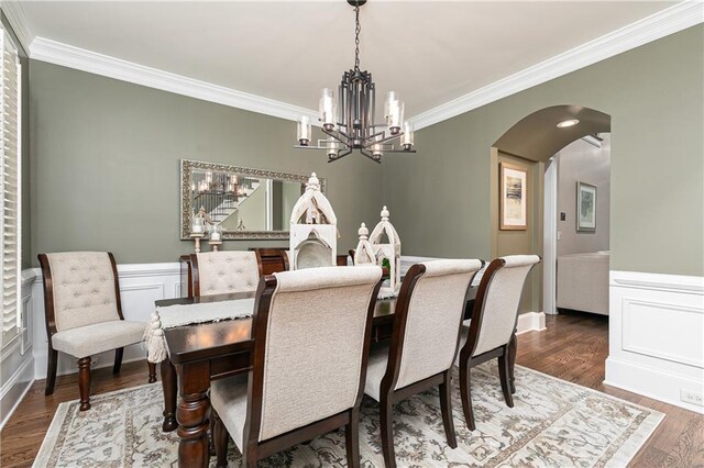 176 Nightwind Trce, Acworth, GA 30101 - dining space featuring ornamental molding, a chandelier, arched walkways, dark wood finished floors, and a wainscoted wall