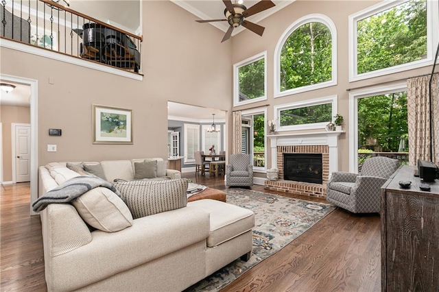 176 Nightwind Trce, Acworth, GA 30101 - living room with a towering ceiling, ceiling fan, wood finished floors, a brick fireplace, and a chandelier