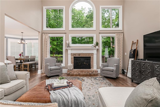 176 Nightwind Trce, Acworth, GA 30101 - living area featuring a chandelier, a high ceiling, wood finished floors, and a brick fireplace