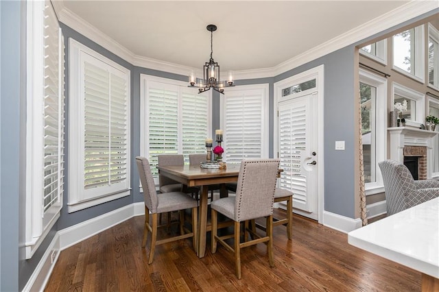 176 Nightwind Trce, Acworth, GA 30101 - dining area featuring a chandelier, baseboards, wood finished floors, crown molding, and a brick fireplace