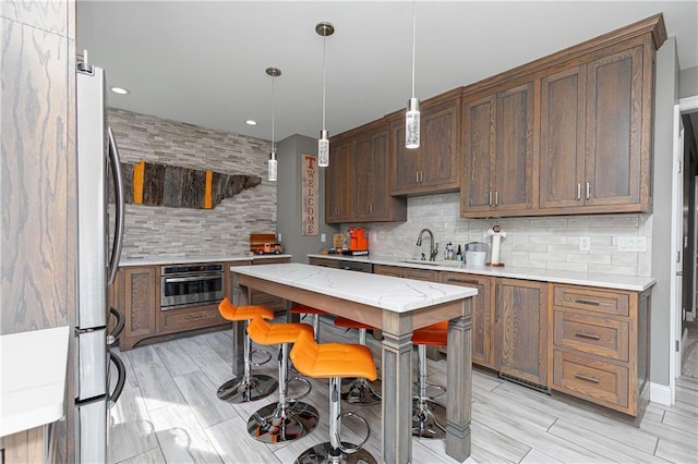 176 Nightwind Trce, Acworth, GA 30101 - kitchen with stainless steel appliances, backsplash, a sink, hanging light fixtures, and light stone countertops
