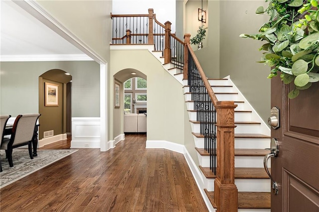 176 Nightwind Trce, Acworth, GA 30101 - foyer entrance featuring arched walkways, dark wood-type flooring, stairway, crown molding, and baseboards