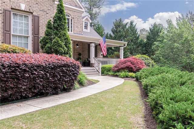 176 Nightwind Trce, Acworth, GA 30101 - property entrance featuring brick siding, a porch, and a lawn