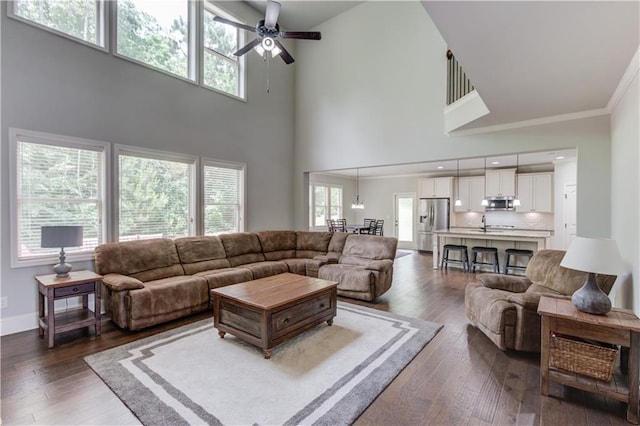 4241 Summer Breeze Way, Buford, GA 30518 - living room with a ceiling fan, a high ceiling, dark wood-style floors, baseboards, and ornamental molding