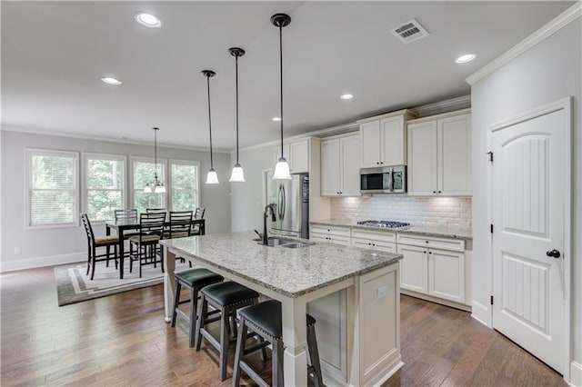 4241 Summer Breeze Way, Buford, GA 30518 - kitchen with stainless steel appliances, crown molding, a sink, tasteful backsplash, and an island with sink