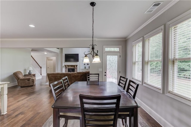 4241 Summer Breeze Way, Buford, GA 30518 - dining room featuring a fireplace, dark wood-style flooring, stairs, baseboards, and crown molding
