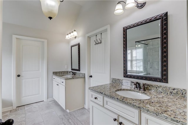 4241 Summer Breeze Way, Buford, GA 30518 - bathroom featuring two vanities, a tile shower, vaulted ceiling, and baseboards