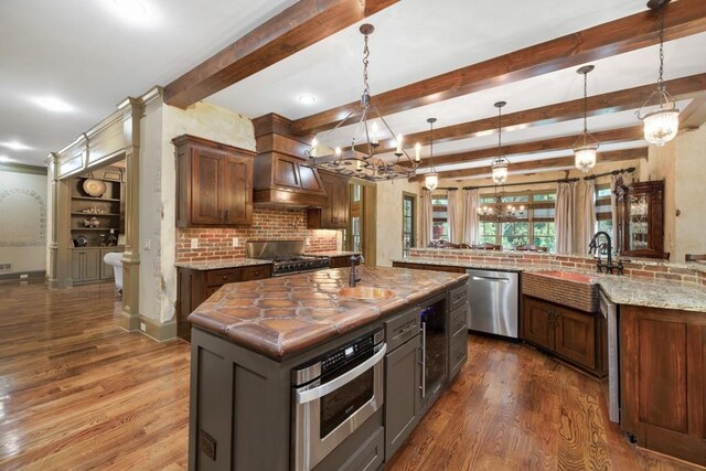 2740 Drayton Hall Dr, Buford, GA 30519 - kitchen featuring a large island with sink, dark wood-style flooring, a sink, stainless steel appliances, and backsplash