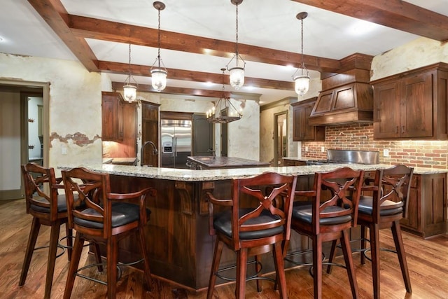 2740 Drayton Hall Dr, Buford, GA 30519 - kitchen featuring premium range hood, beam ceiling, wood finished floors, light stone countertops, and stainless steel built in refrigerator