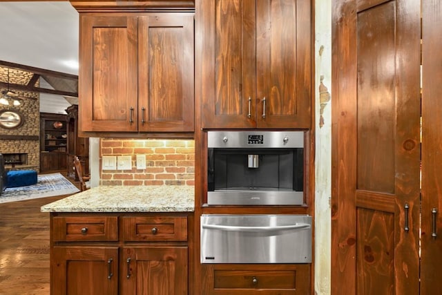 2740 Drayton Hall Dr, Buford, GA 30519 - kitchen featuring light stone countertops, a stone fireplace, a warming drawer, wood finished floors, and oven