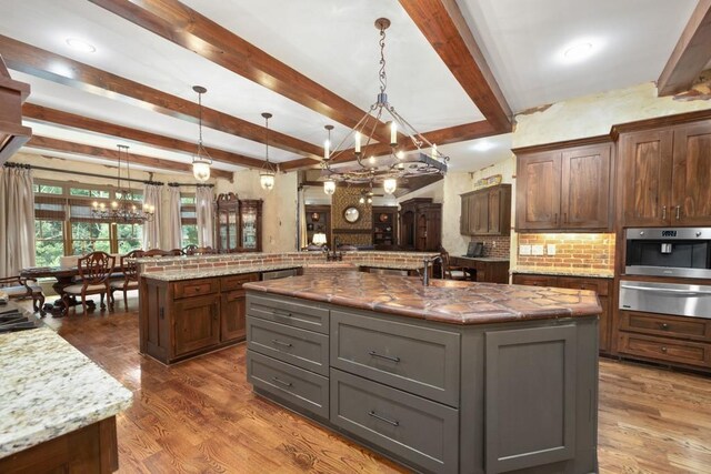 2740 Drayton Hall Dr, Buford, GA 30519 - kitchen featuring a notable chandelier, stainless steel oven, backsplash, a warming drawer, and a spacious island