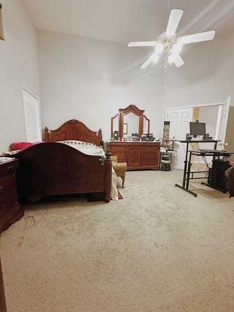 carpeted bedroom featuring high vaulted ceiling and ceiling fan