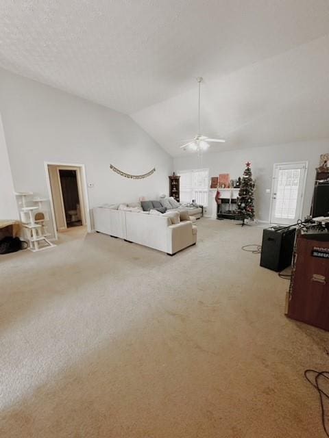 unfurnished living room with lofted ceiling, ceiling fan, and light carpet