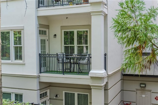 view of side of home featuring a balcony and stucco siding
