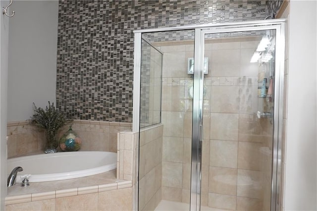 bathroom featuring a stall shower and a bath