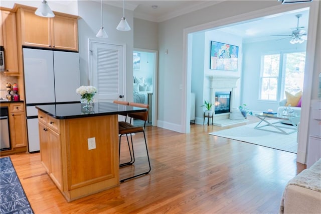 kitchen featuring open floor plan, white fridge, light wood finished floors, and crown molding