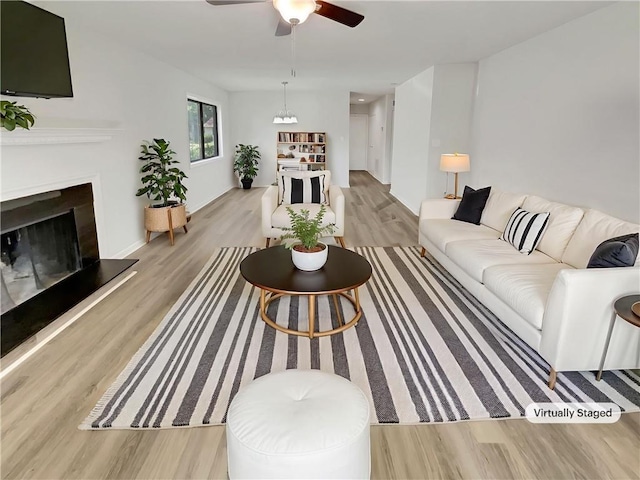 1152 Country Ct, Lawrenceville, GA 30044 - living area with wood finished floors, ceiling fan, and a fireplace with raised hearth