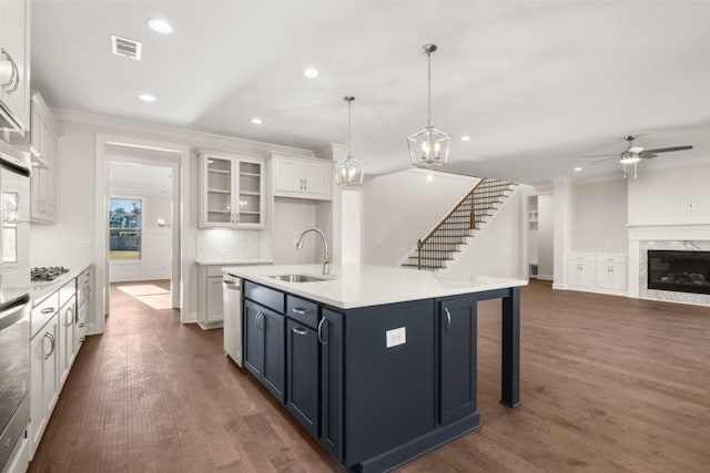 kitchen with visible vents, crown molding, dark wood-style floors, white cabinets, and a sink