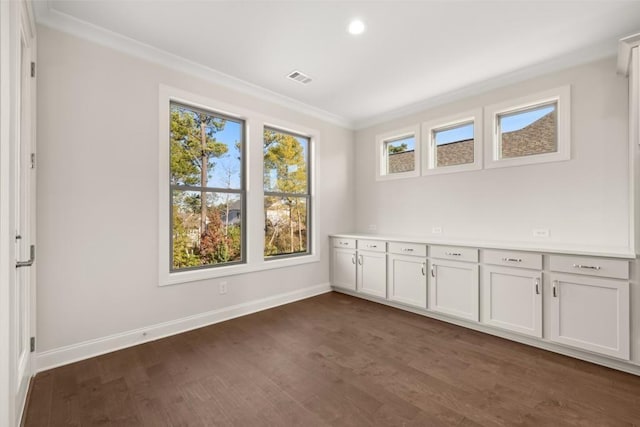 spare room featuring recessed lighting, baseboards, dark wood-type flooring, visible vents, and ornamental molding