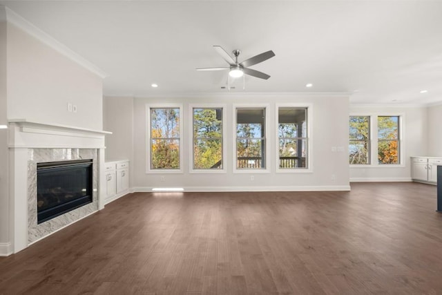 unfurnished living room featuring crown molding, a ceiling fan, baseboards, and dark wood-type flooring
