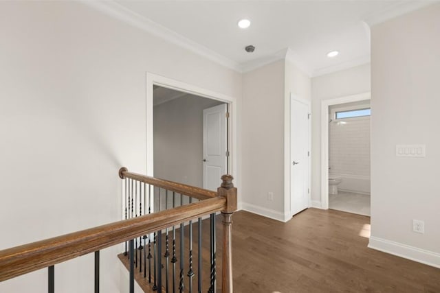 hallway with crown molding, wood finished floors, baseboards, recessed lighting, and an upstairs landing