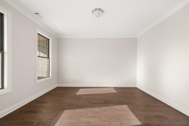 empty room with crown molding, baseboards, visible vents, and wood finished floors