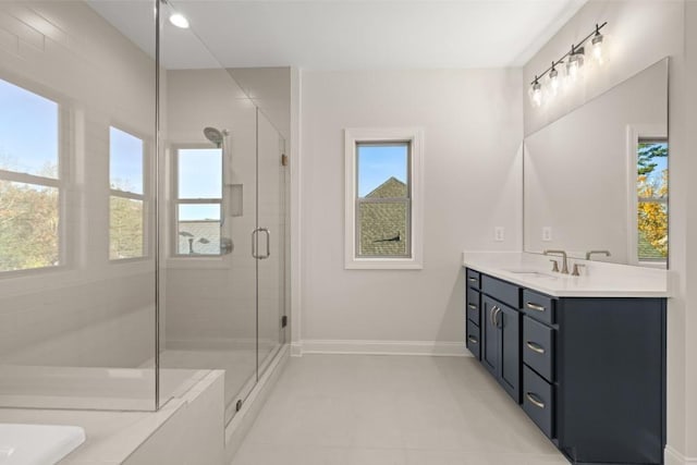 bathroom featuring vanity, baseboards, a bathtub, tile patterned floors, and a shower stall
