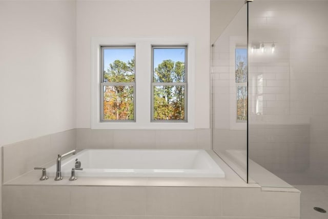 full bath with a tile shower and a garden tub