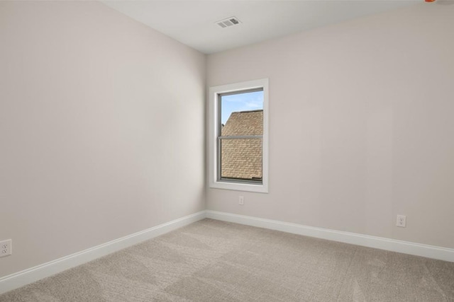 unfurnished room with baseboards, visible vents, and light carpet