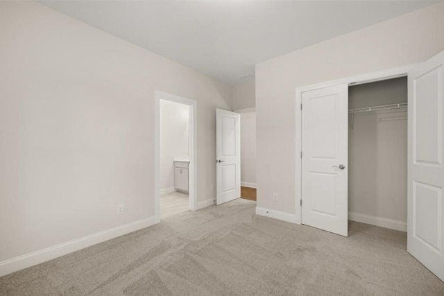 unfurnished bedroom featuring baseboards, carpet flooring, connected bathroom, and a closet