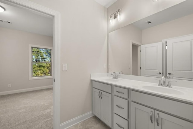 bathroom with baseboards, visible vents, and a sink