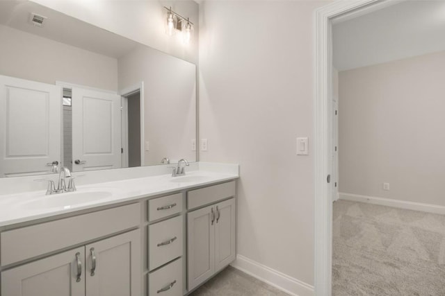 bathroom featuring baseboards, visible vents, and a sink