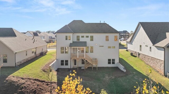 back of property featuring stairway, a lawn, a residential view, and a wooden deck