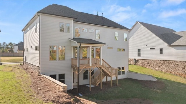 rear view of property with a lawn, stairs, and a wooden deck