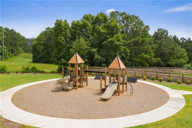 community play area featuring fence and a yard