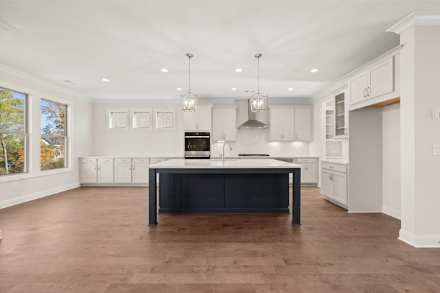 kitchen with recessed lighting, light countertops, wall chimney exhaust hood, and white cabinetry