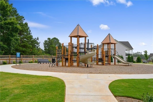 community jungle gym with a lawn and fence