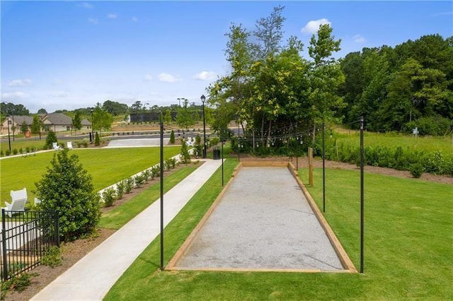 surrounding community with fence and a yard