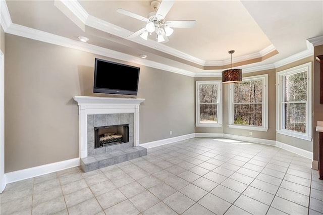 unfurnished living room featuring a raised ceiling, ornamental molding, a fireplace, light tile patterned floors, and baseboards