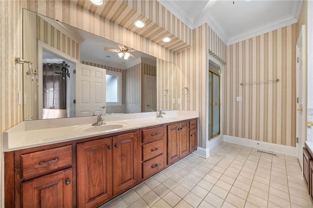 bathroom with wallpapered walls, crown molding, baseboards, and a sink