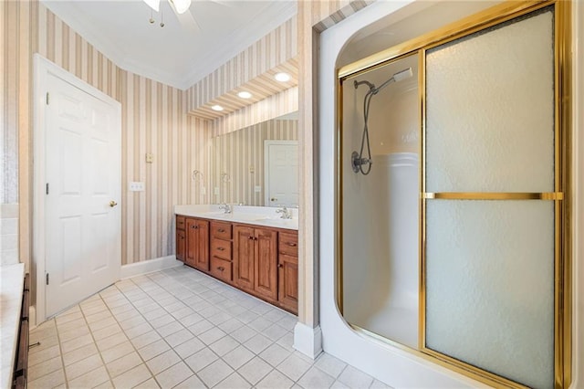 bathroom with tile patterned flooring, wallpapered walls, crown molding, a stall shower, and a sink