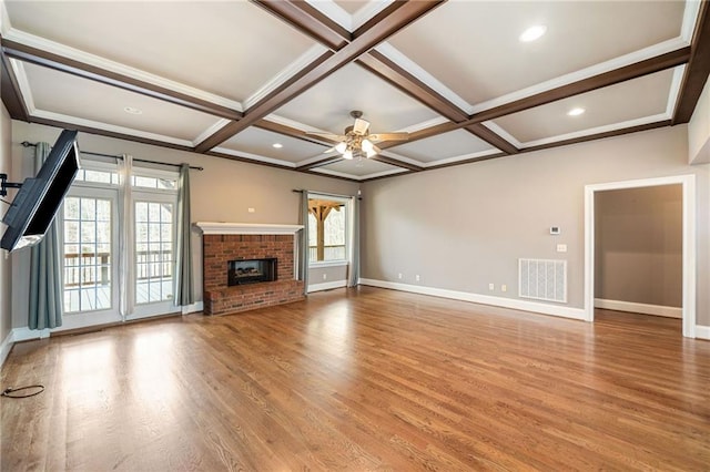 unfurnished living room with visible vents, coffered ceiling, light wood-style floors, a brick fireplace, and ceiling fan