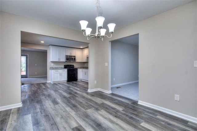 kitchen featuring decorative light fixtures, dark wood-type flooring, white cabinetry, black / electric stove, and an inviting chandelier