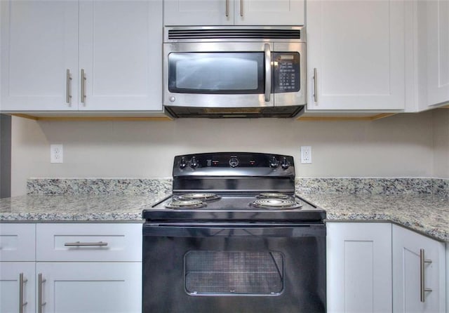 kitchen with white cabinets and black electric range