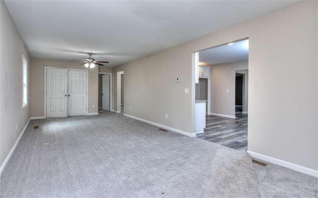 unfurnished room featuring ceiling fan and dark carpet