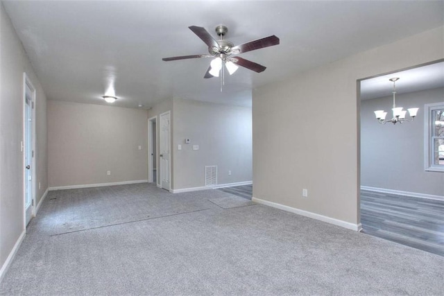 carpeted empty room with ceiling fan with notable chandelier