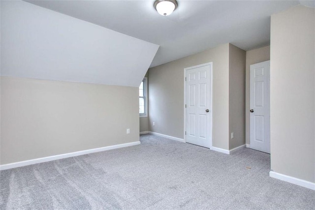 additional living space with carpet floors and vaulted ceiling