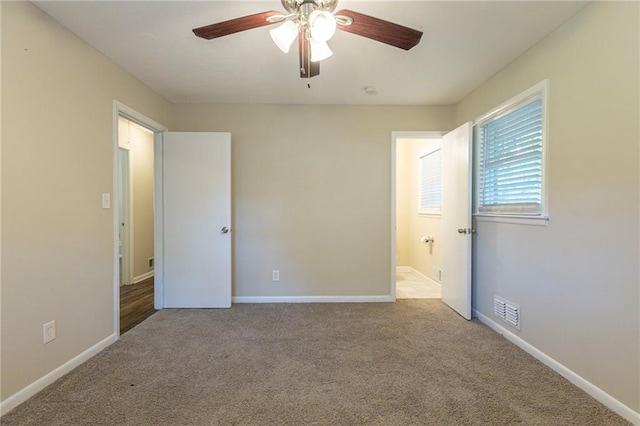 unfurnished bedroom with ensuite bathroom, ceiling fan, and light colored carpet